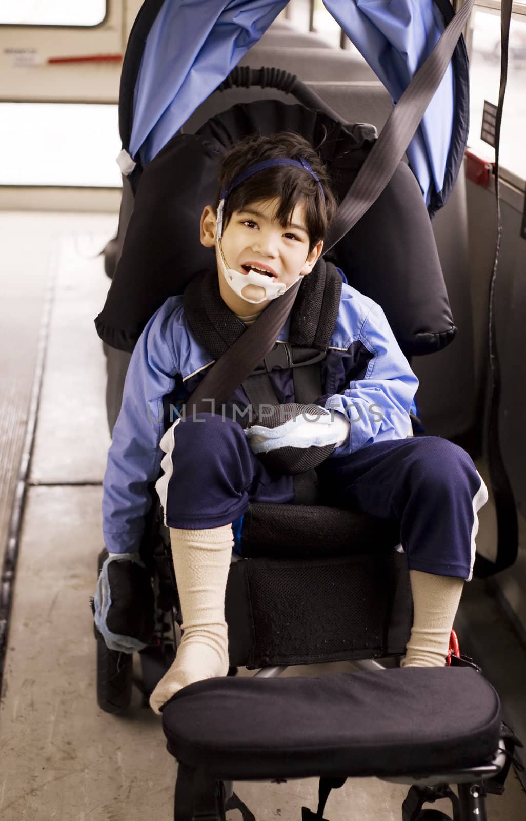 Disabled little preschool boy in wheelchair on bus by jarenwicklund