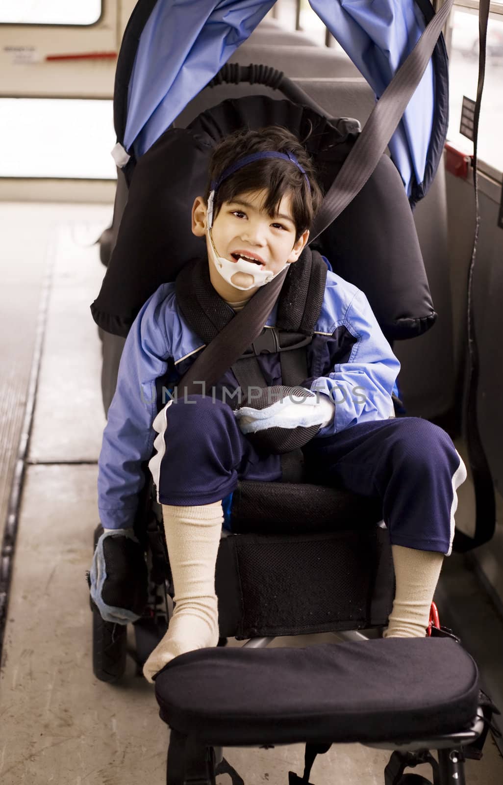 Disabled little preschool boy in wheelchair on bus. Child has cerebral palsy.