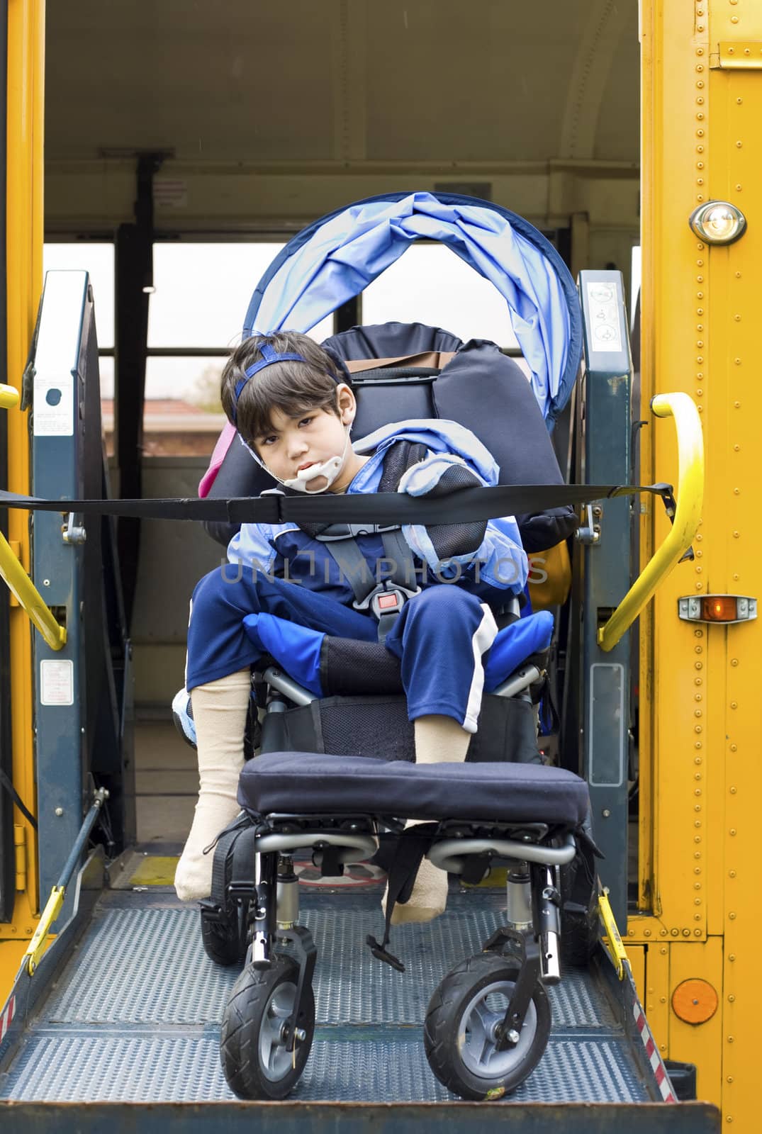 Disabled little boy on school bus wheelchair lift by jarenwicklund