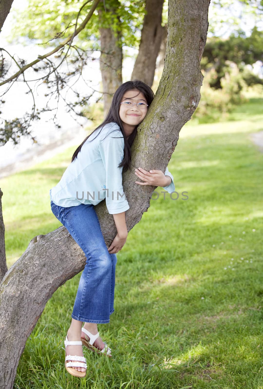 Young girl resting on a tree branch