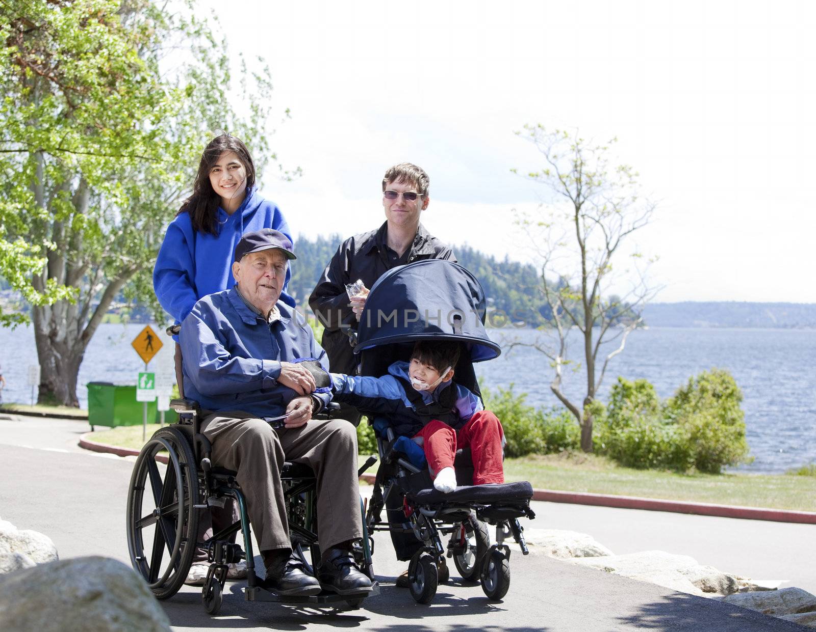 Family with disabled senior and child walking outdoors by jarenwicklund