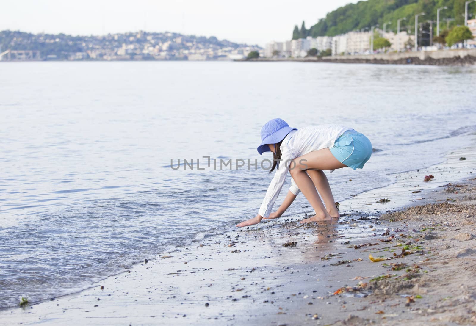 Young girl playing along the shore at the beach