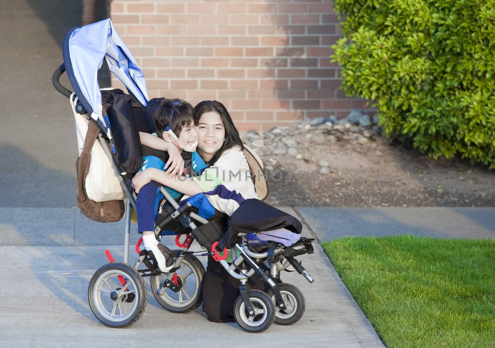 Disabled boy in wheelchair and his sister by jarenwicklund