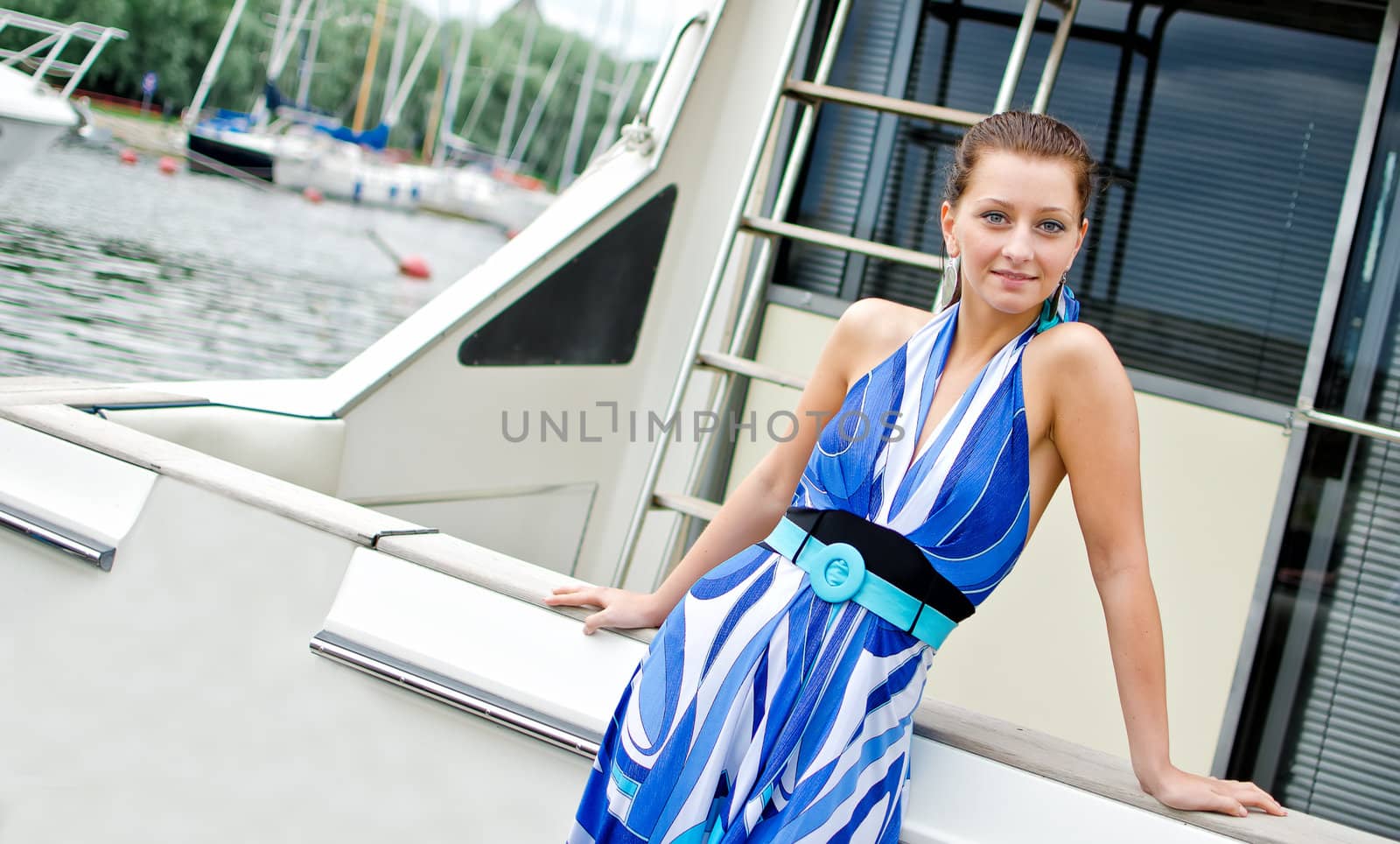 Attractive girl standing on the deck of the yacht