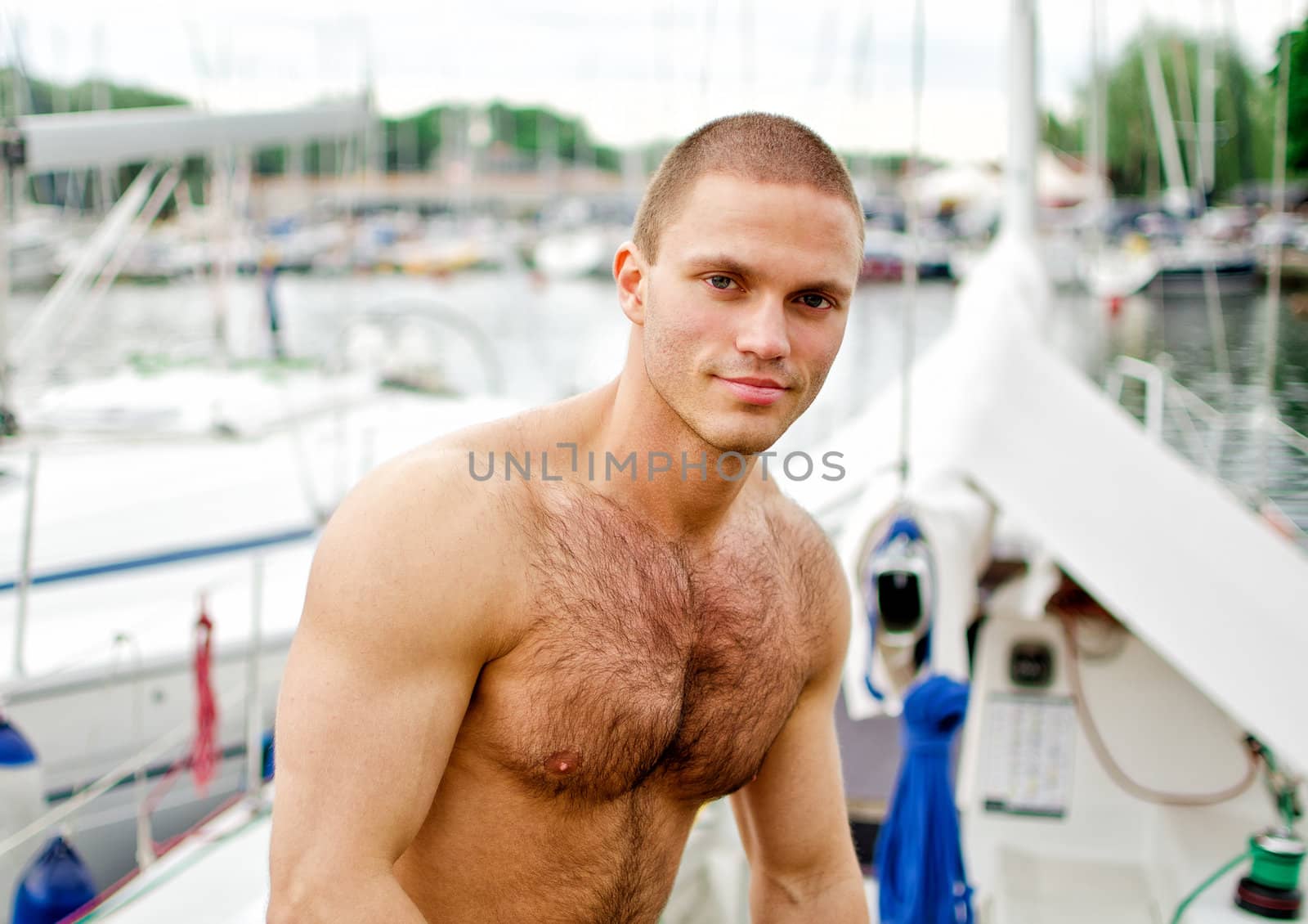 Muscular handsome sailor on his yacht.