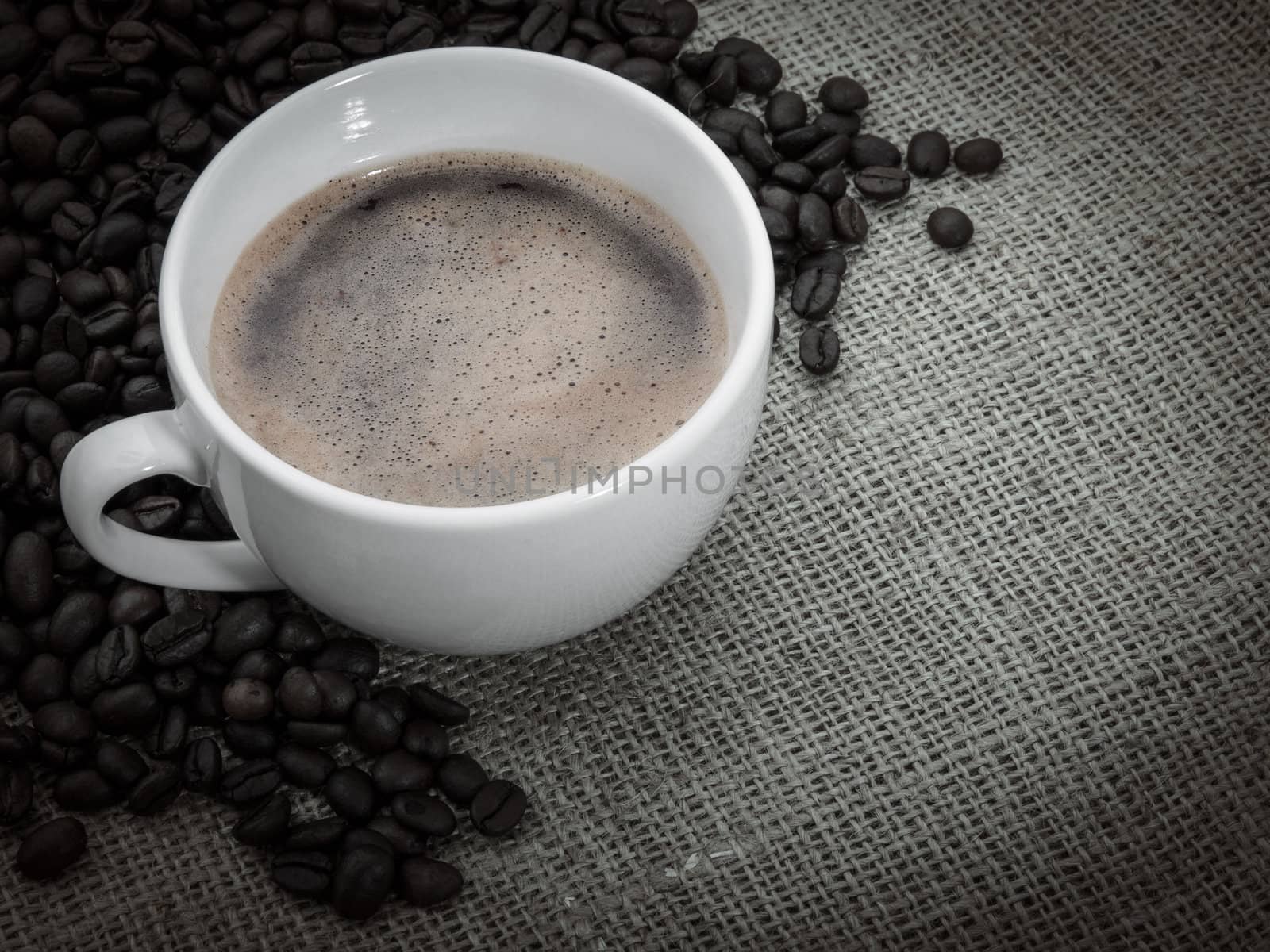 Black coffee over old burlap background