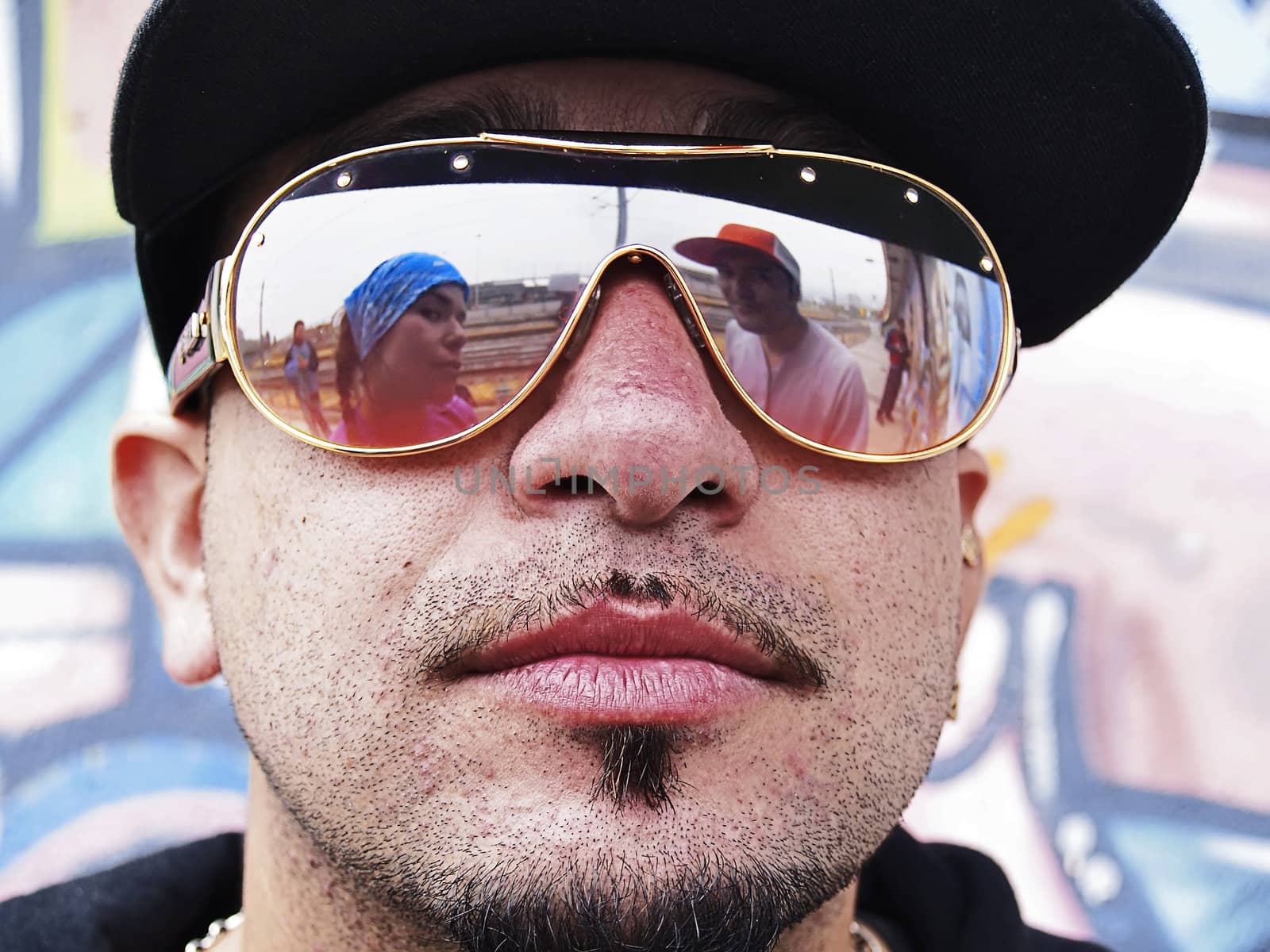 Portrait of three rappers, two of them reflected on the sunglasses of the other