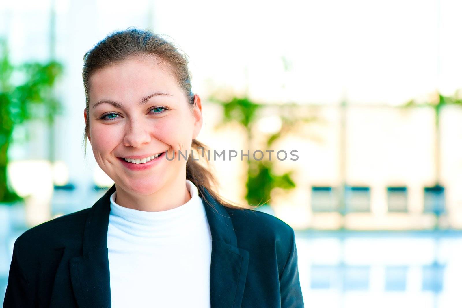 Portrait of a smiling girl on the background of the manager de-focus office interior