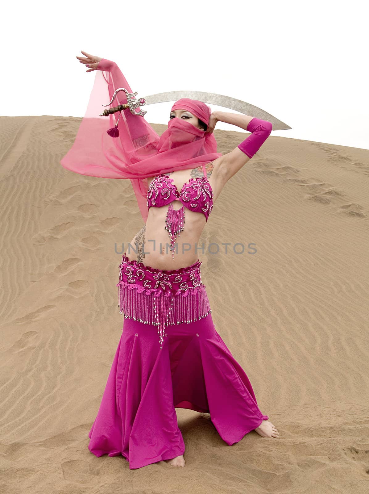 Touareg woman dancing at the desert with a sabre over her head