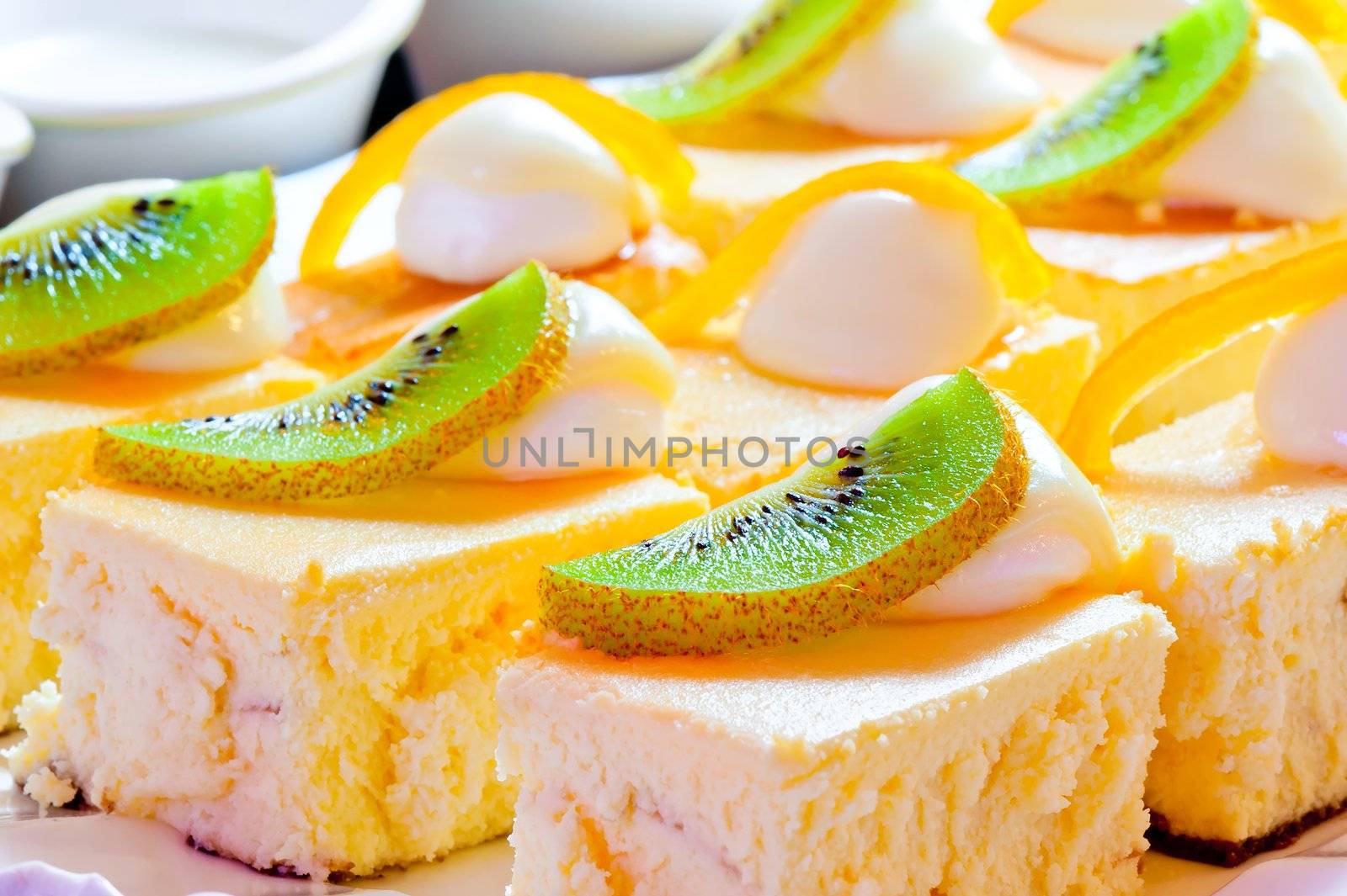 Cottage cheese pie decorated with a slice of kiwi and orange zest