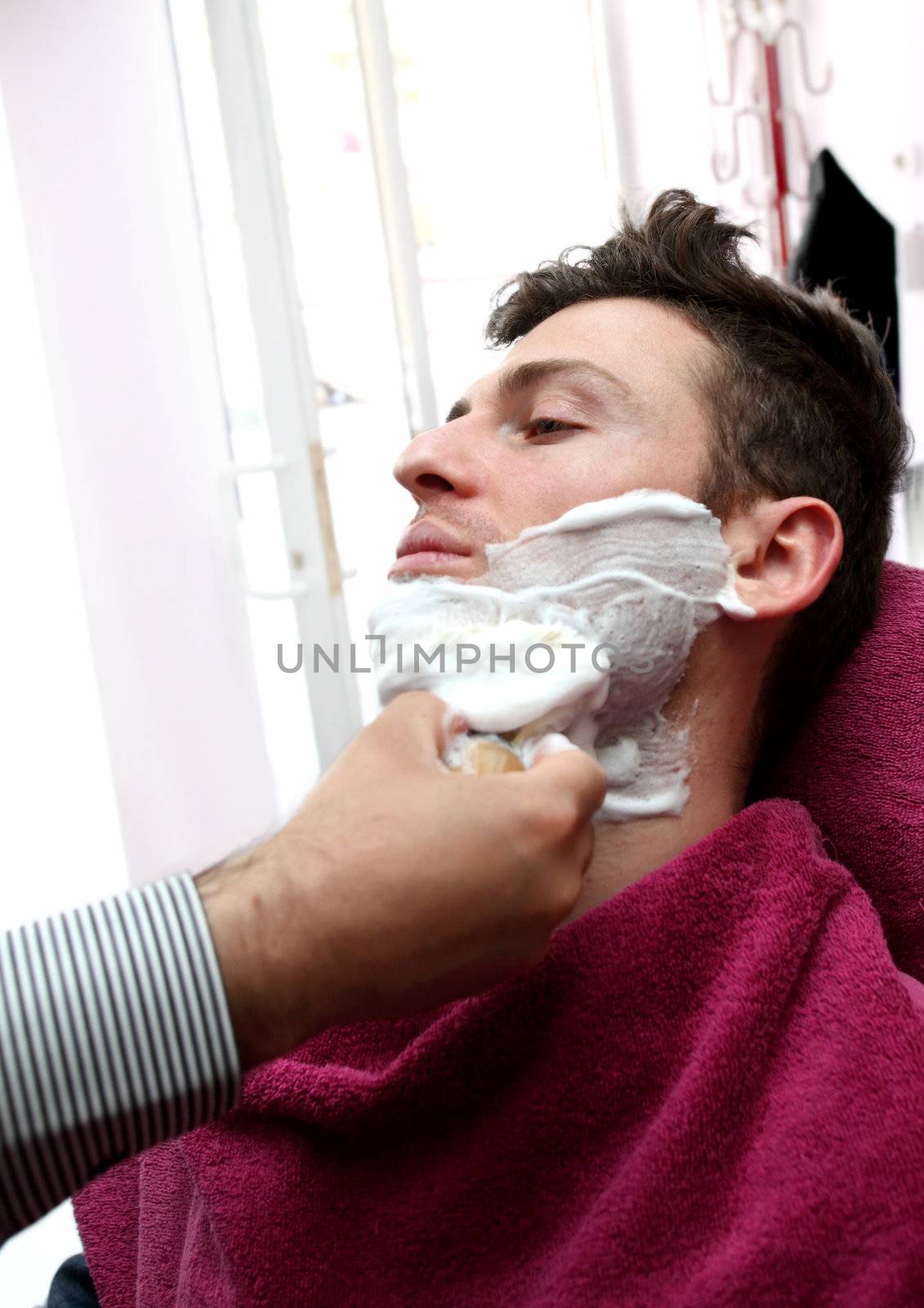 Young adult at barber shop for shaving