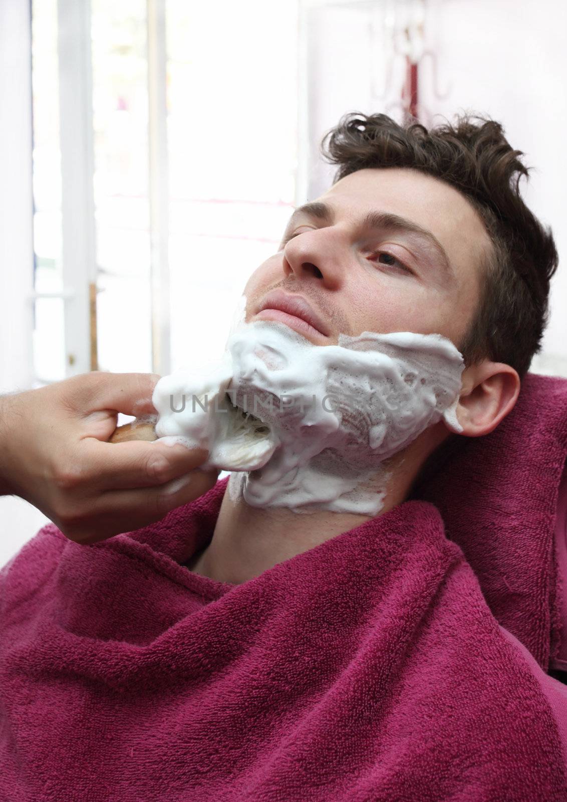 Young adult at barber shop for shaving