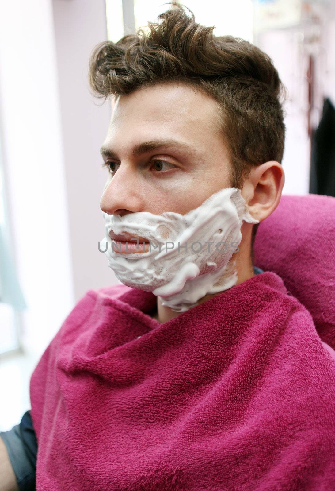 Young adult at barber shop for shaving