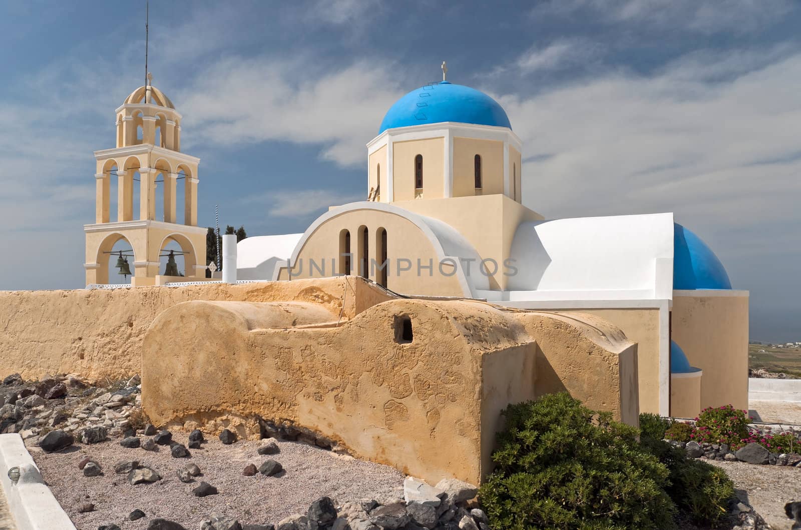 Yellow greek church with blue cupola and belltower