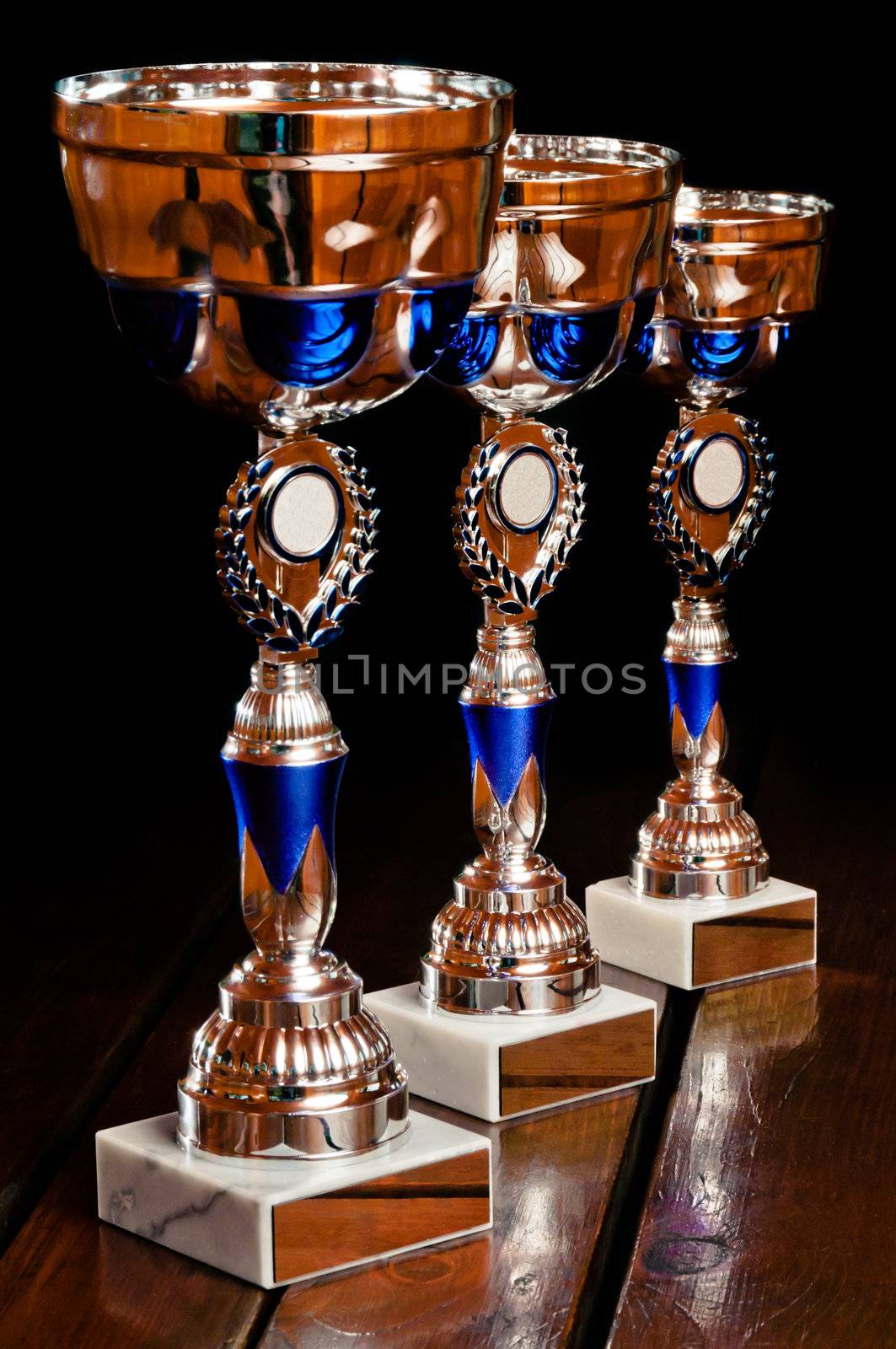 Three main tournament prizes standing on the wooden table