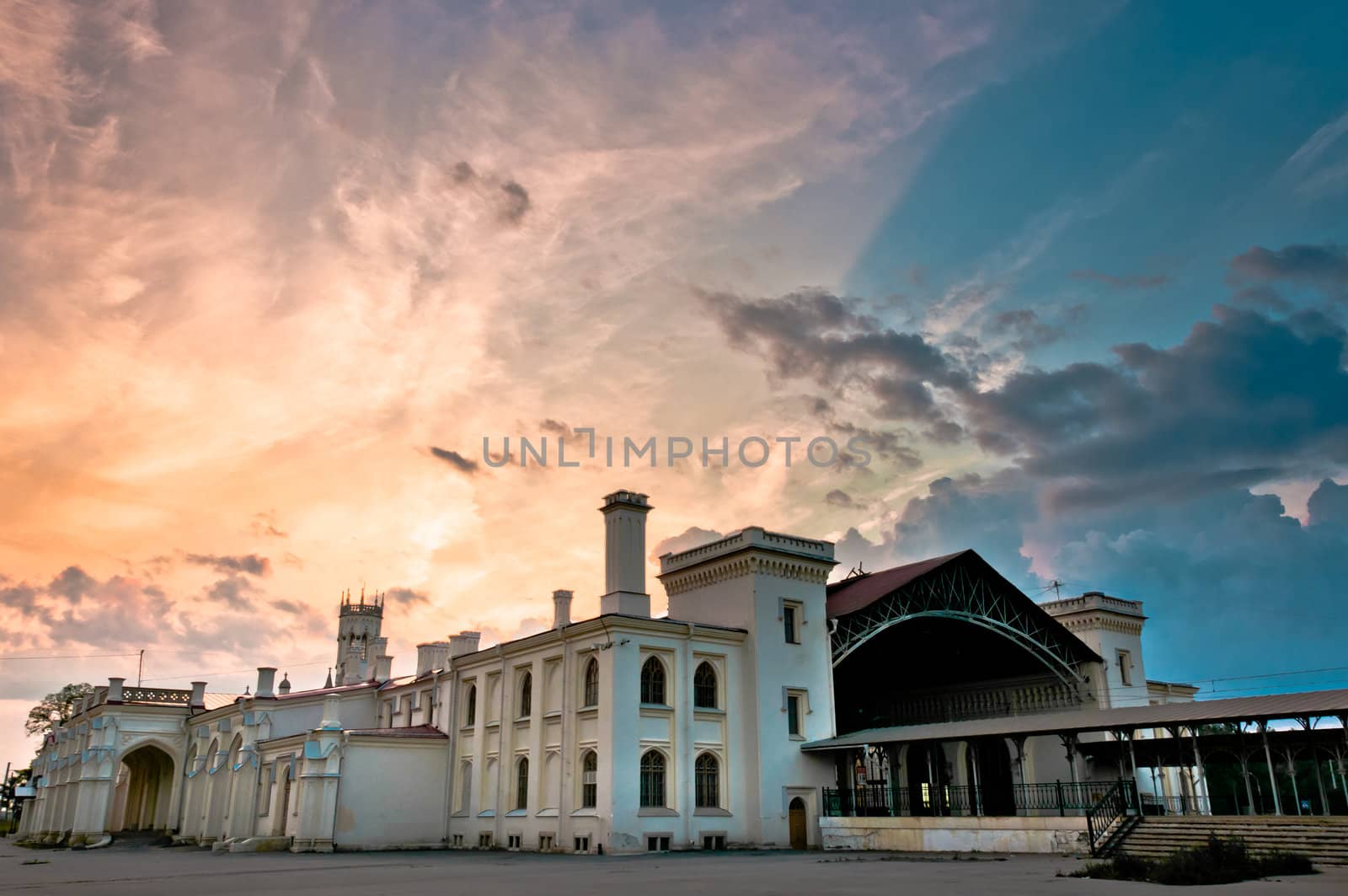 Old railway station with beautiful and colorful cloudscape on background