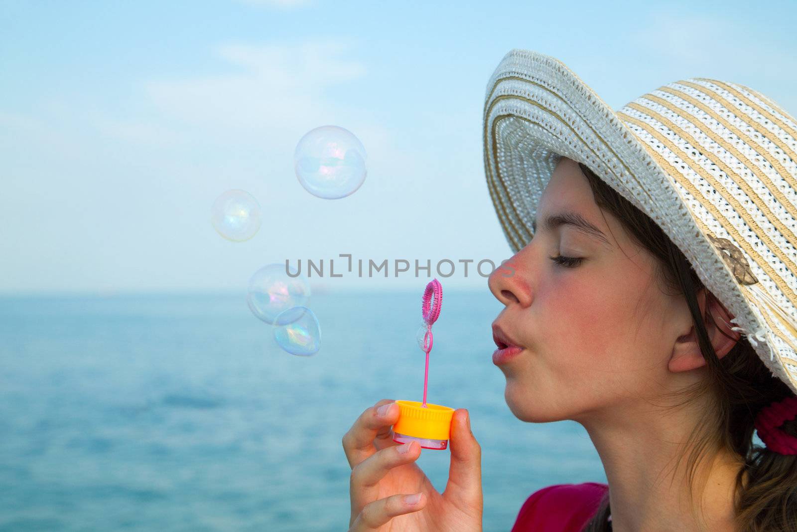 Teen girl blowing bubbles at sea shore