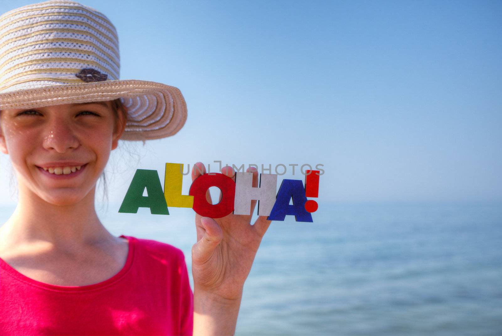 Teen girl at a beach holding word 'Aloha'
