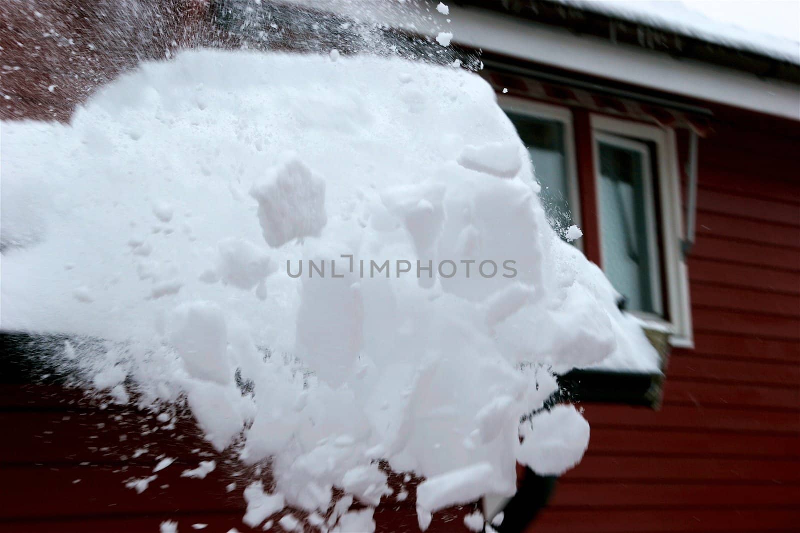 roof and window of a wooden small house covered with snow in the cold winter by Bildehagen