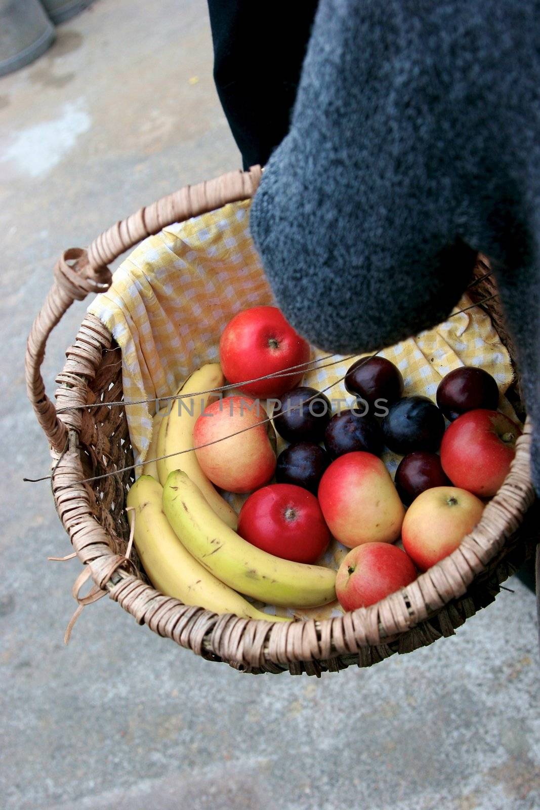 woman holds a basket of fruit by Bildehagen
