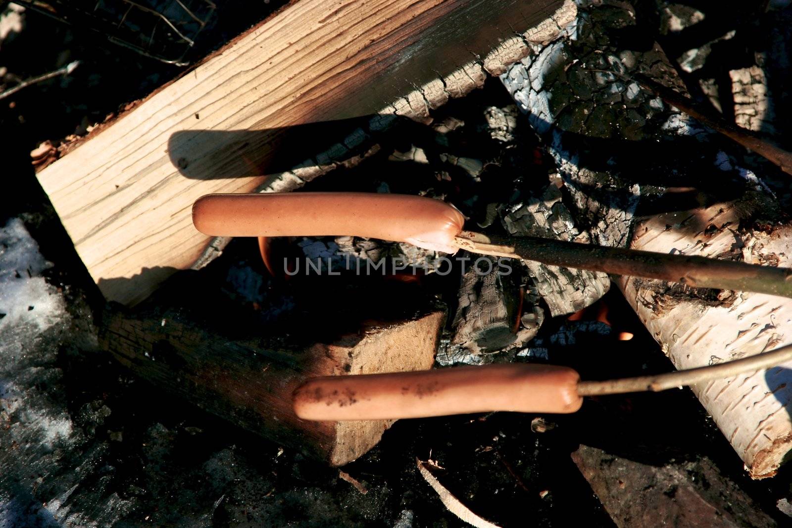 a sausage grilled on a camp fire