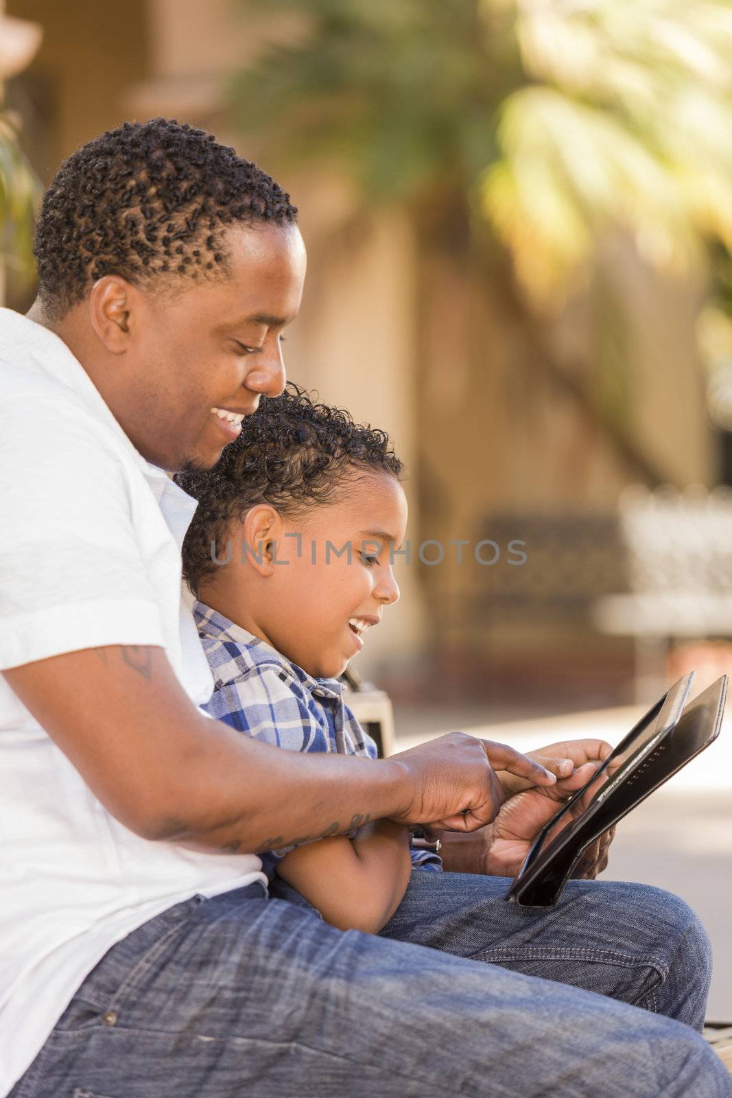 Mixed Race Father and Son Using Touch Pad Computer Tablet by Feverpitched