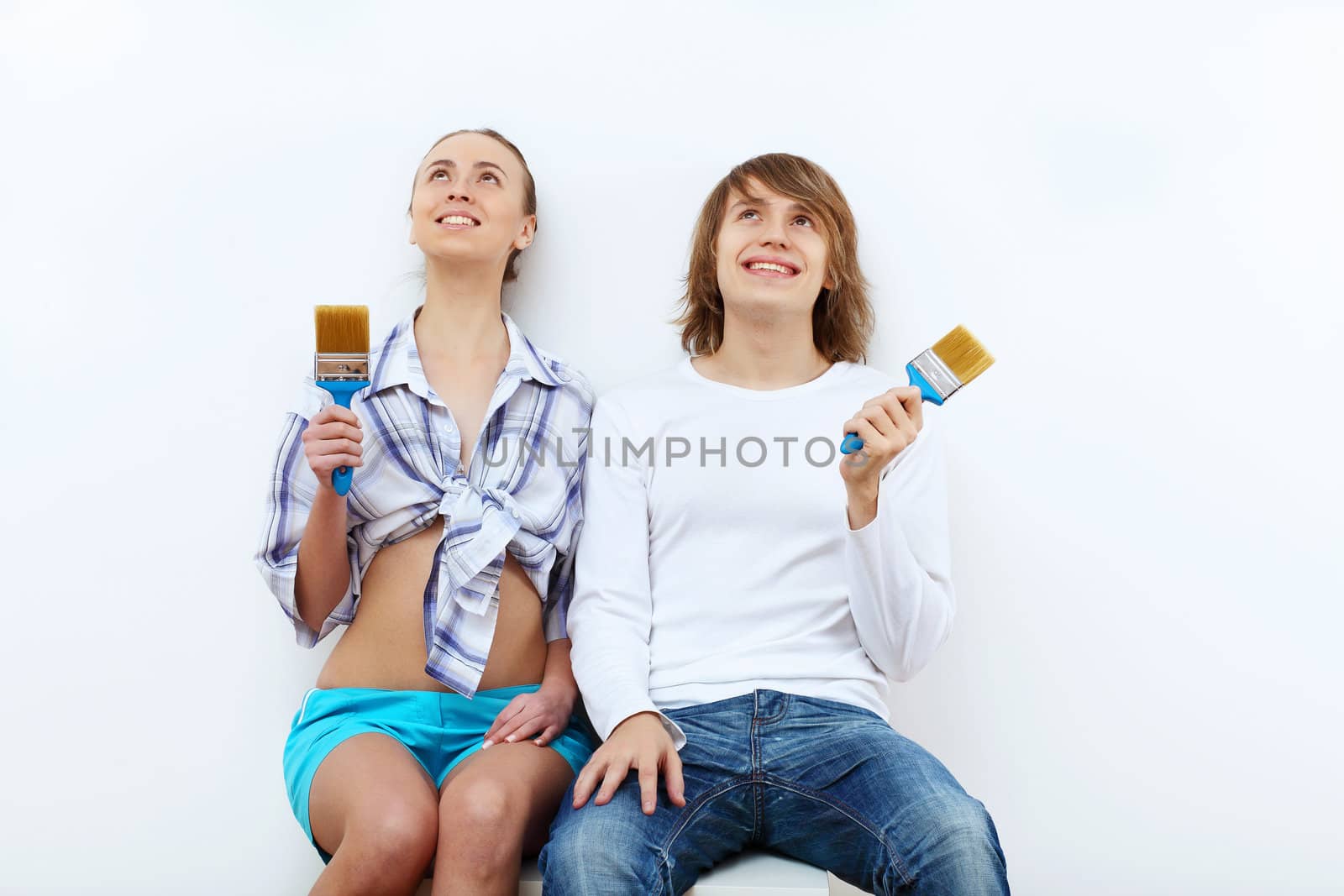 Portrait of young couple with paint brushes