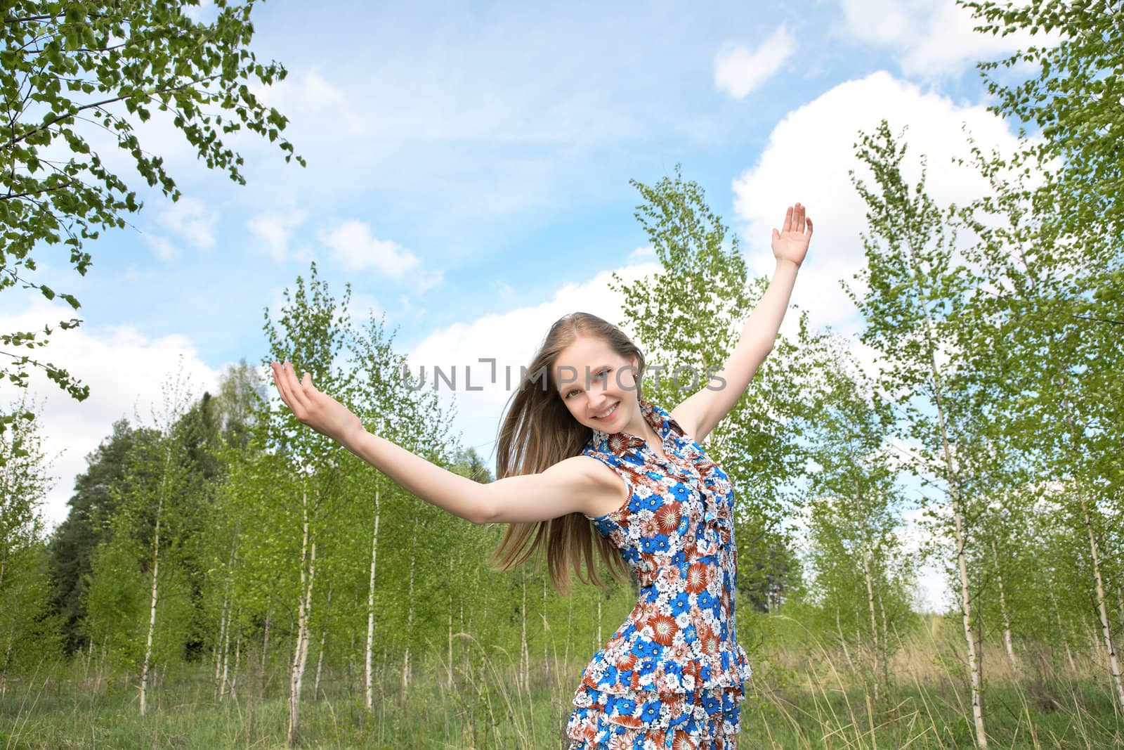 The girl with the lifted hands against  blue sky