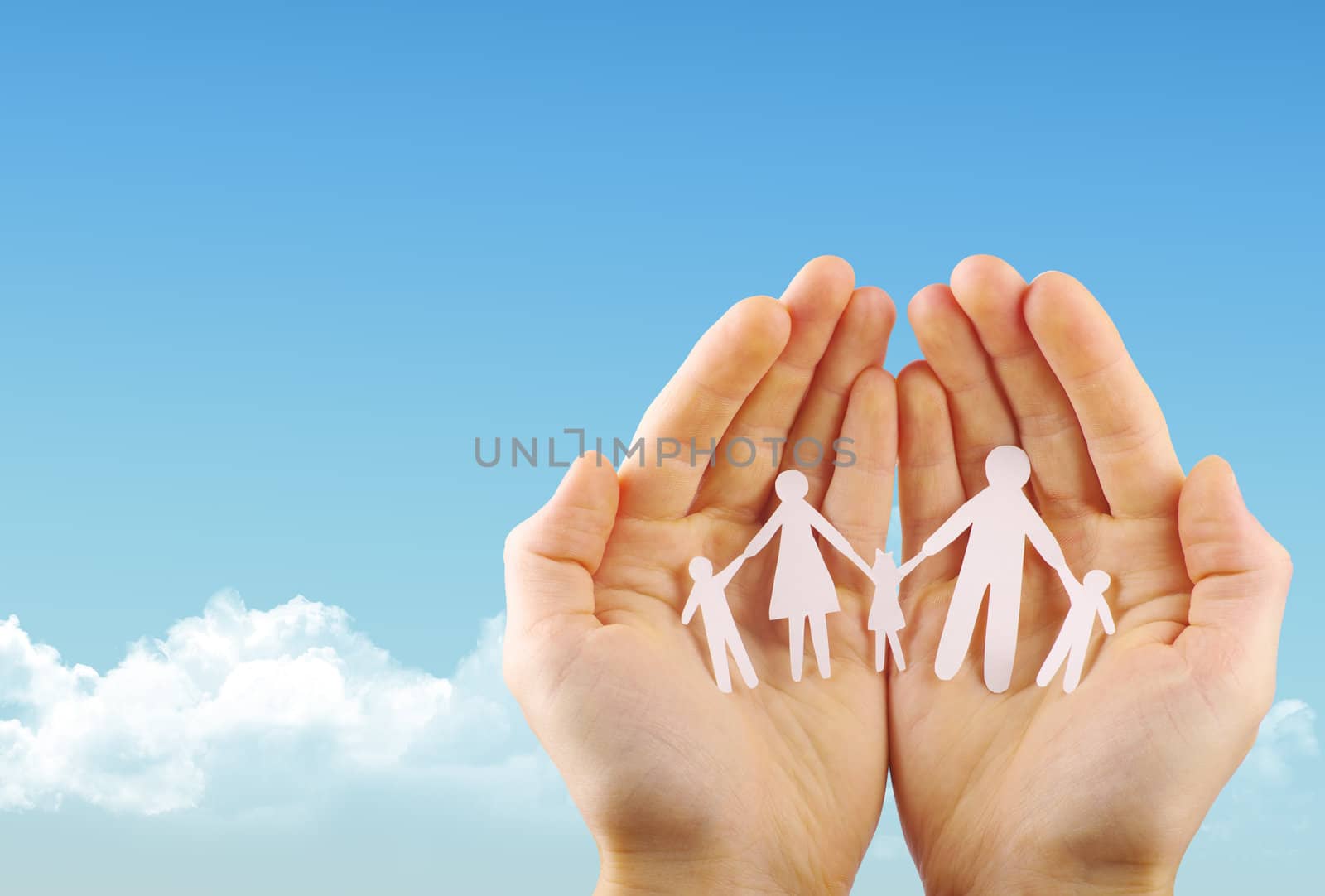 Paper family in hands isolated on blue sky

