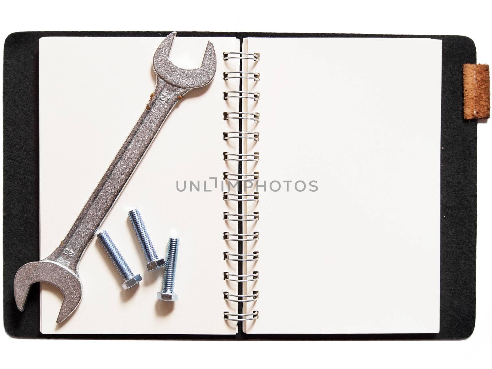 wrench and nuts on notebook, isolated on white background     