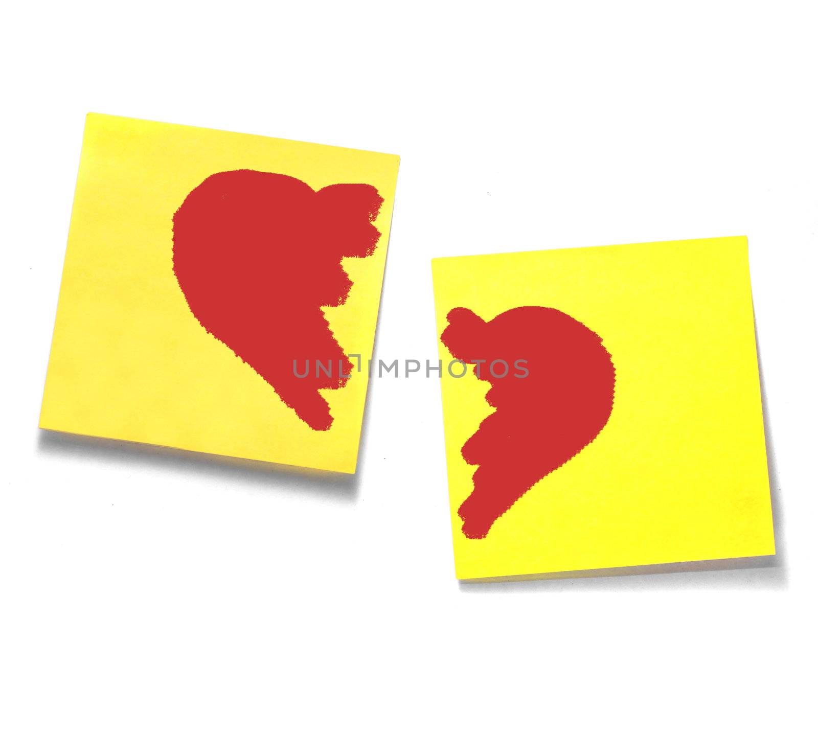 A couple of Yellow sticky notes with separated red hearts on white background.