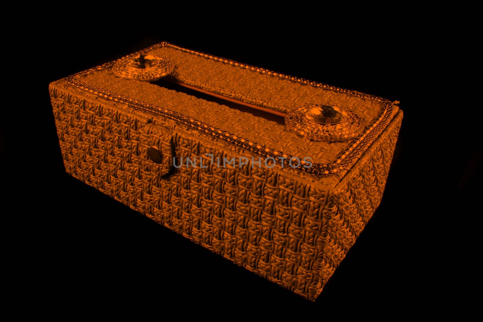 A beautiful orange colored tissue box decorated with precious jewels.