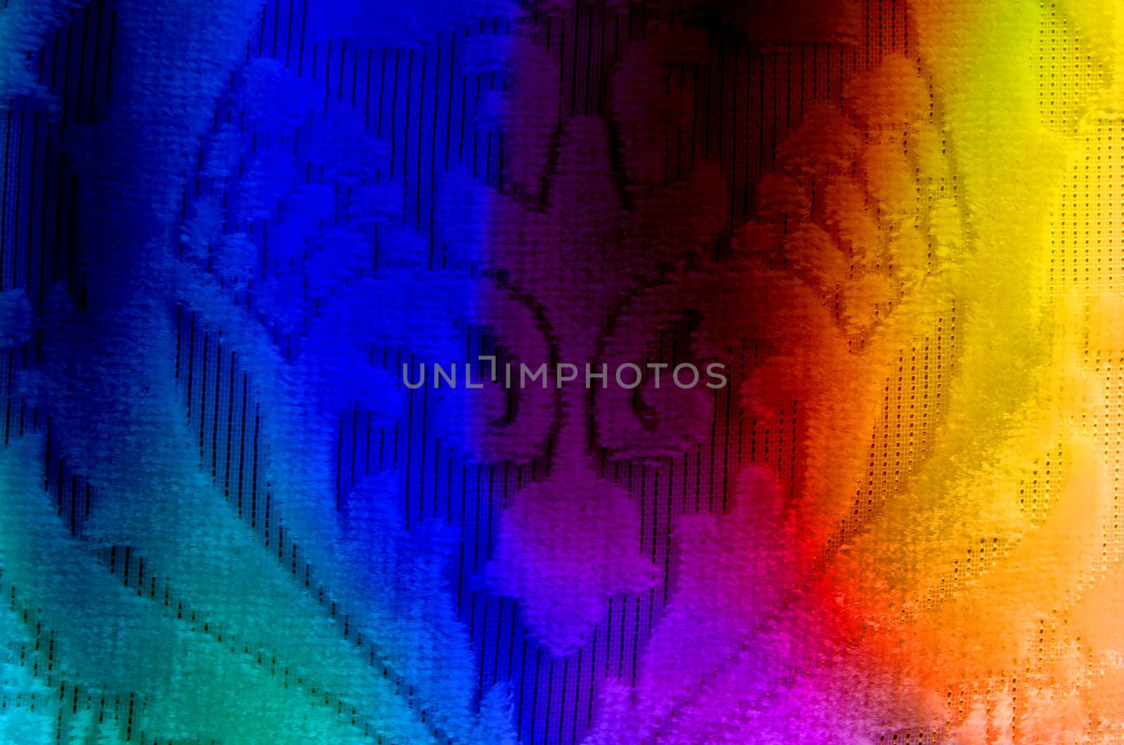 A background of a fabric with floral design, lit in colorful lights.