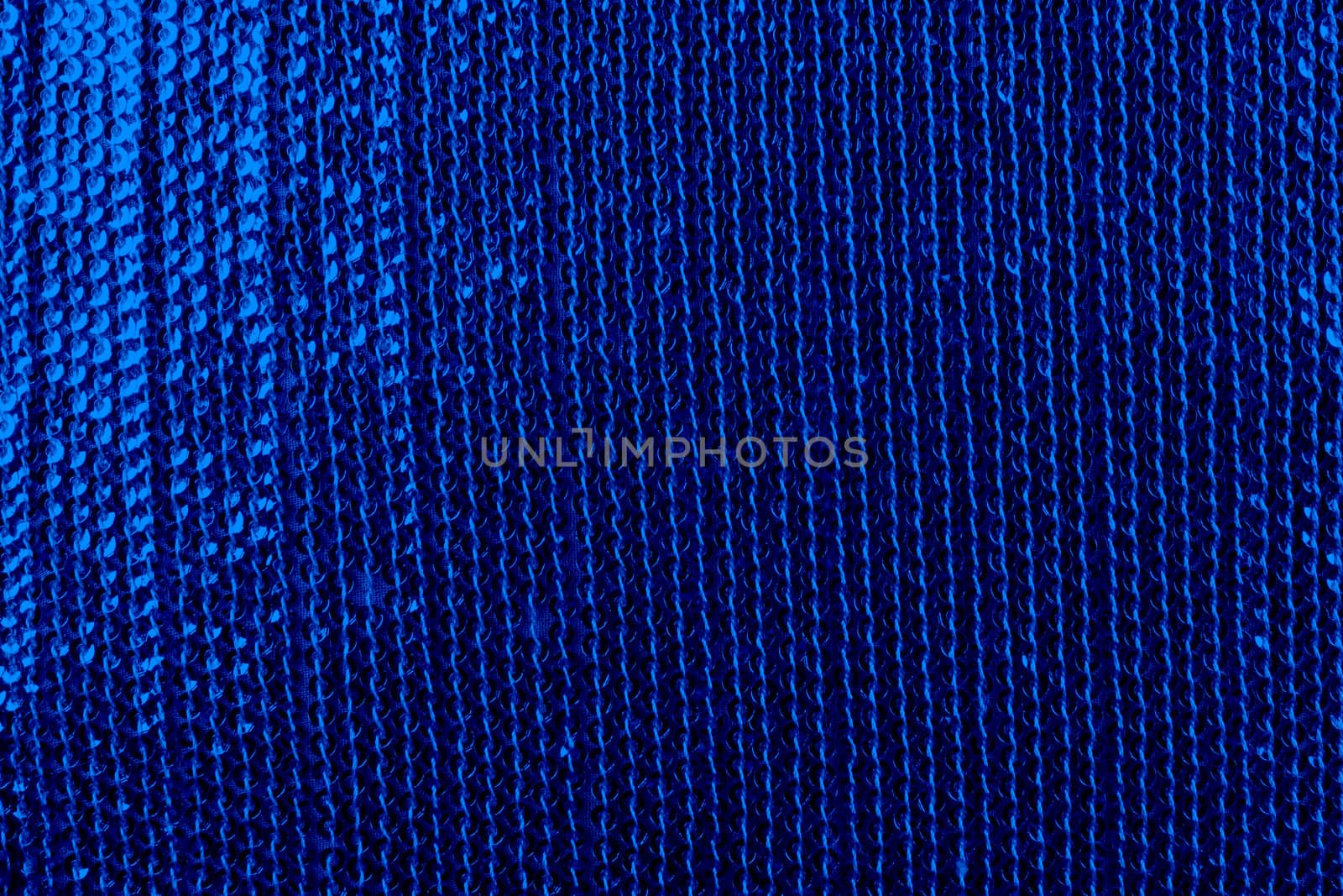 A background of a fabric with sequins, in dark blue color.