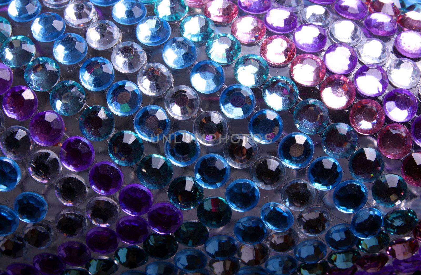 A background of artificial gemstones in different colors.