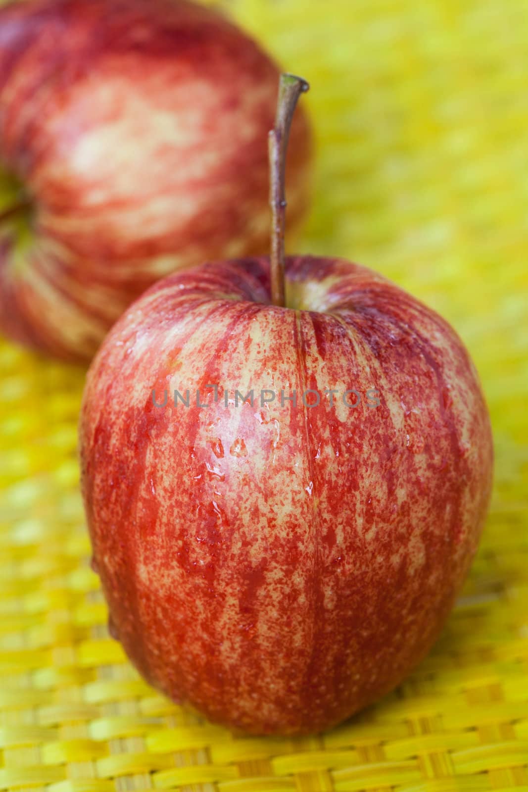 Red apple placed on a bamboo basket.