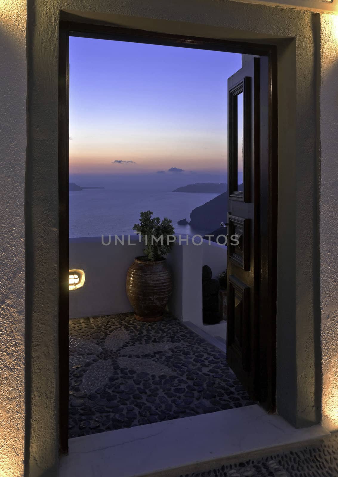 Santorini Caldera twilight view with cliffs trough the open door of the building