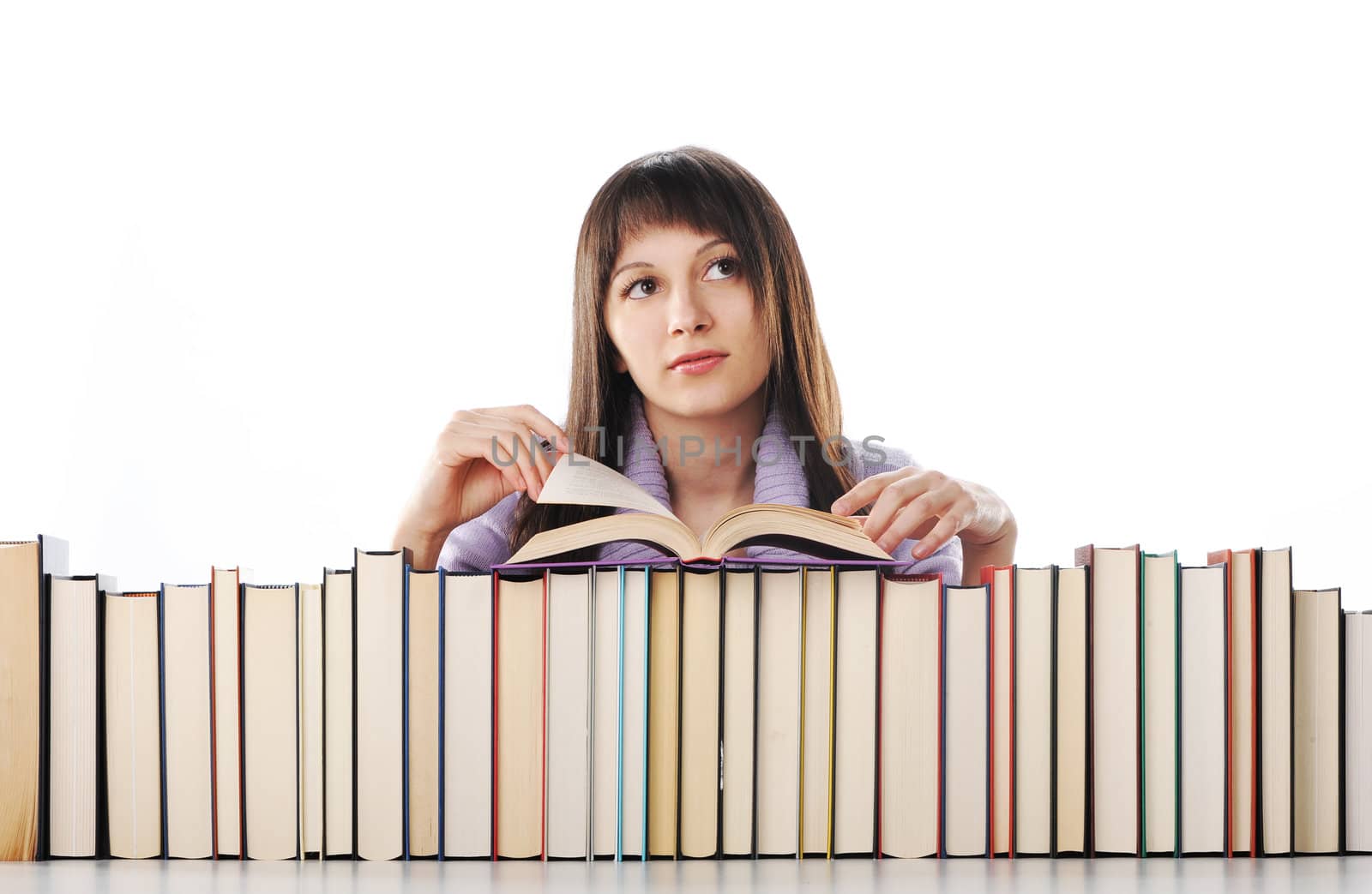 young woman behind a big pile of books 