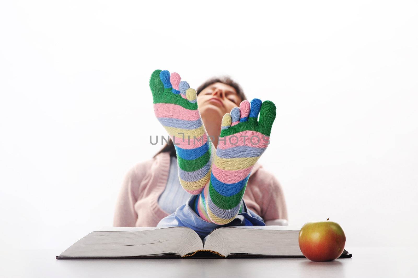 Tired of studies,  student relaxing  with his feet up on his des by stokkete