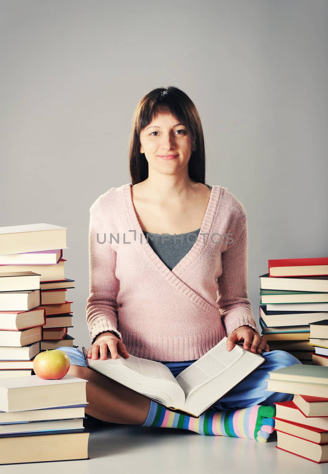 Cute girl studying with a big stack of books