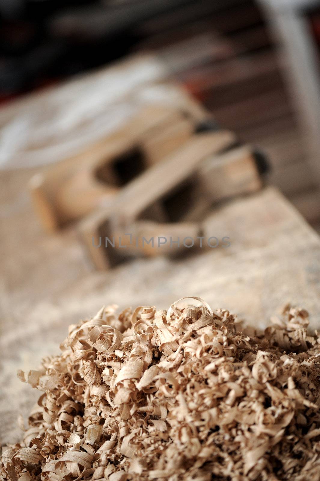 a work table of a carpenter with two hand planers and a pile of wood chips