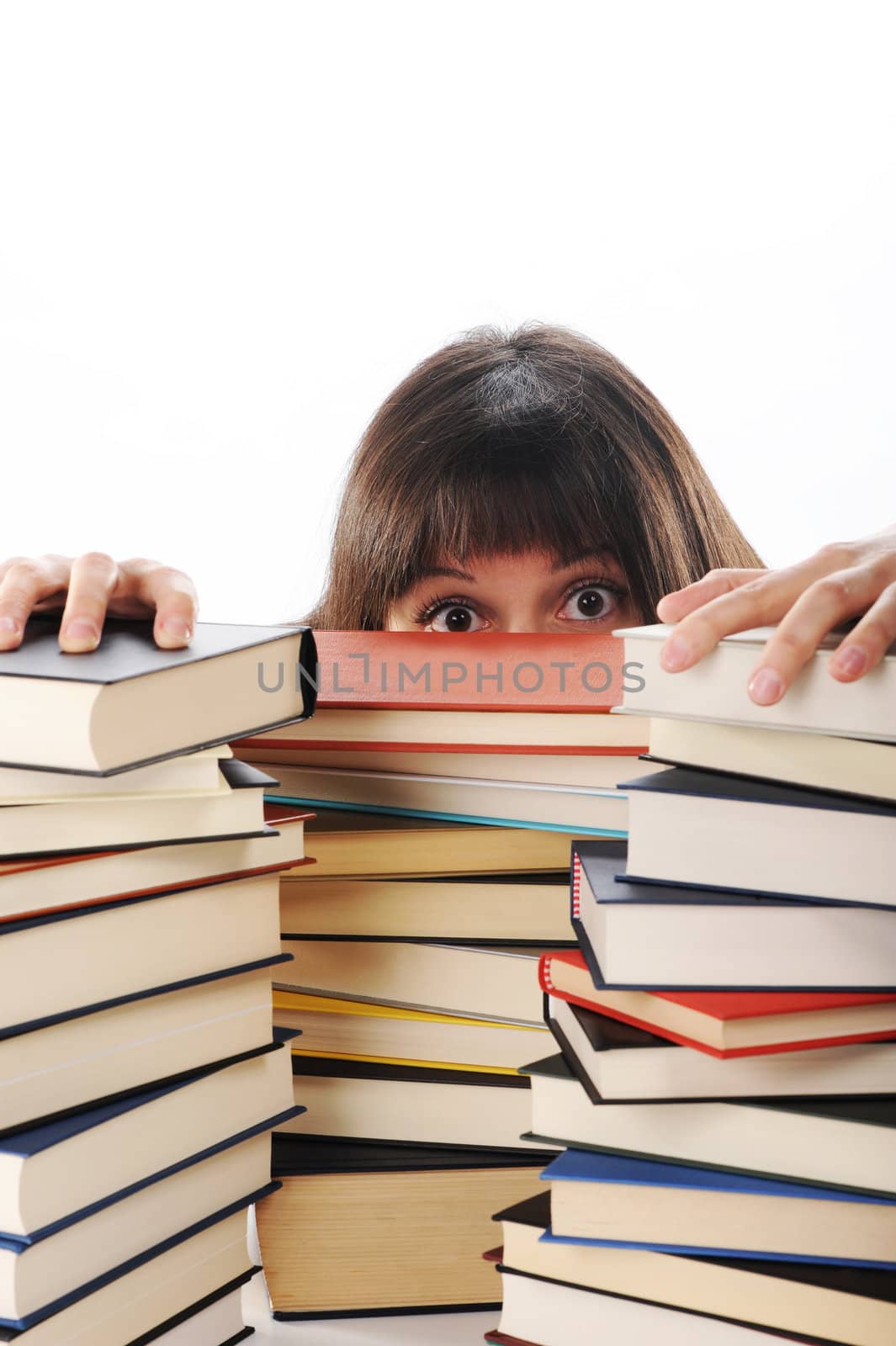 young woman behind a big pile of books 