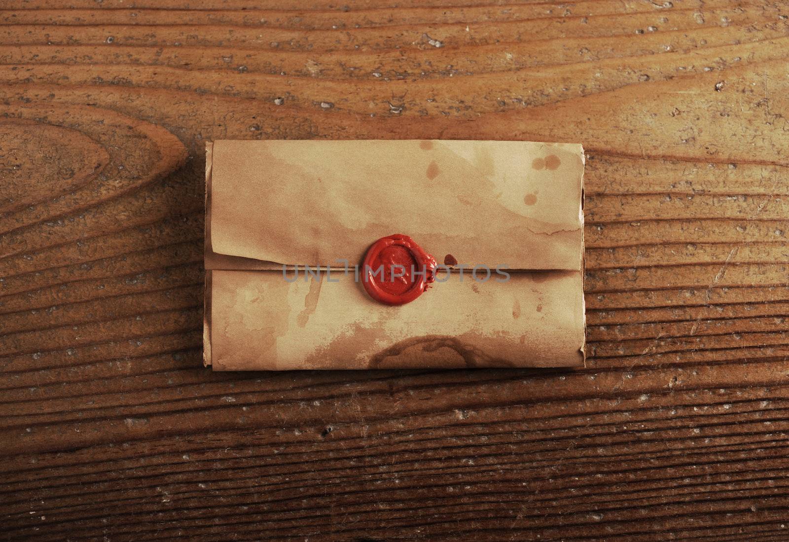 wax seal on a letter paper , background is wooden table by stokkete