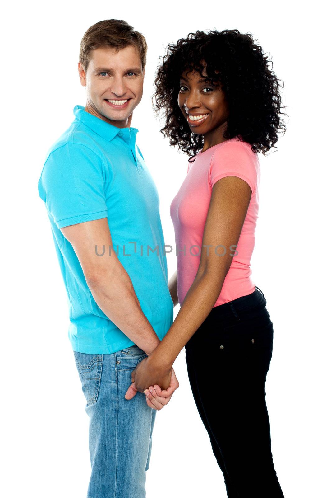 Happy young couple holding hands by stockyimages
