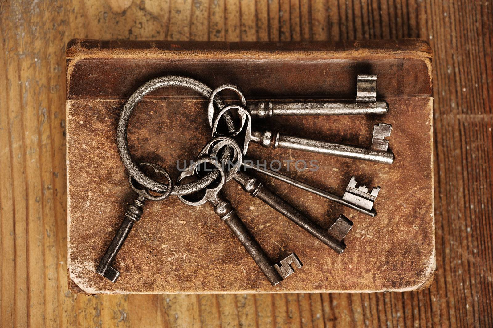 old keys on a old book, antique wood background by stokkete