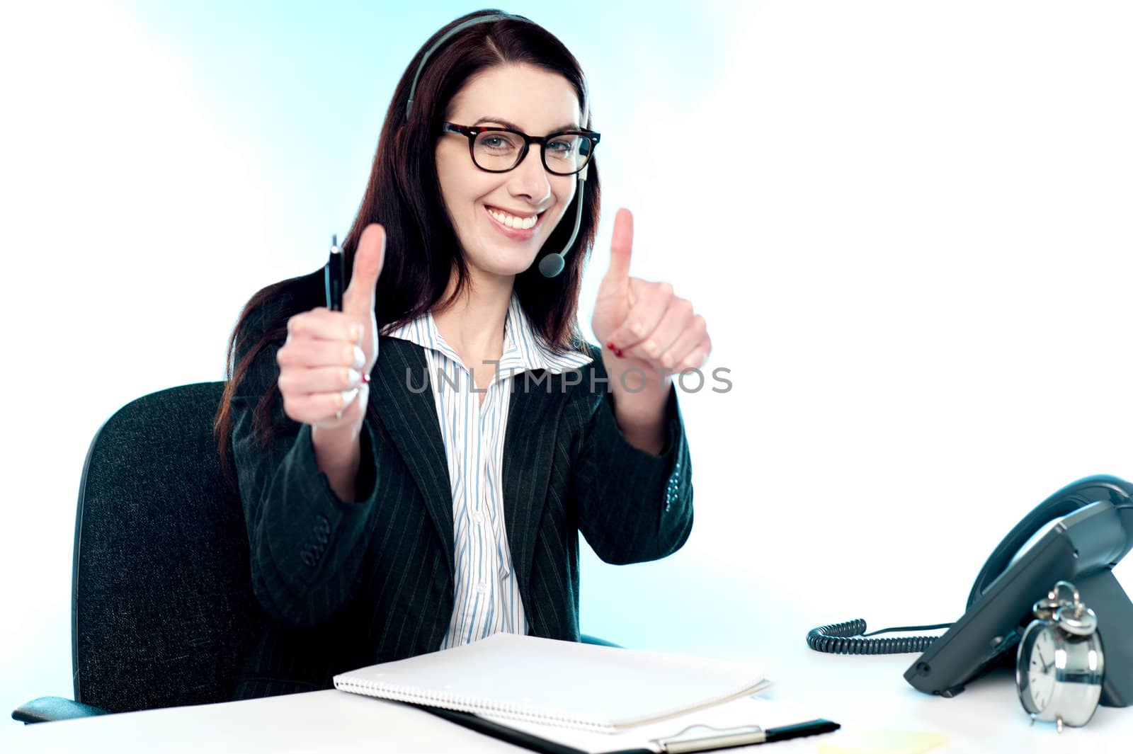 Cheerful female call centre operator gesturing double thumbs up in joy