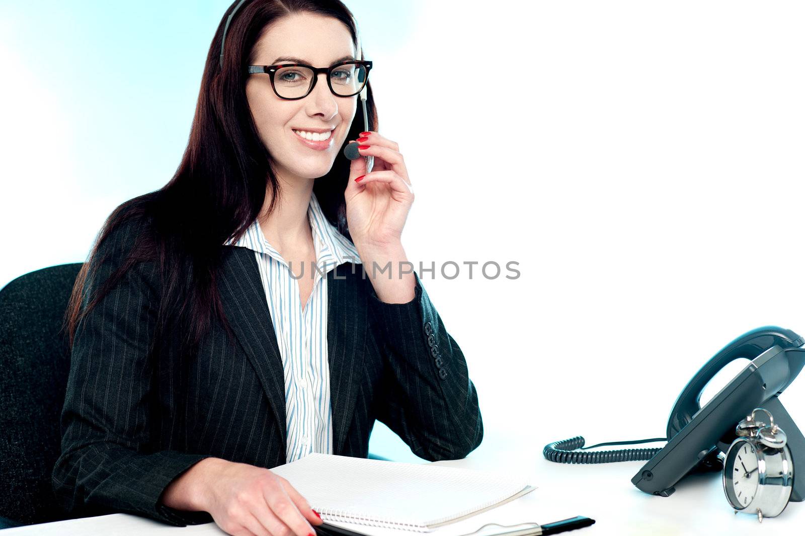 Female customer care executive holding mic and assisting customer. Smiling at camera