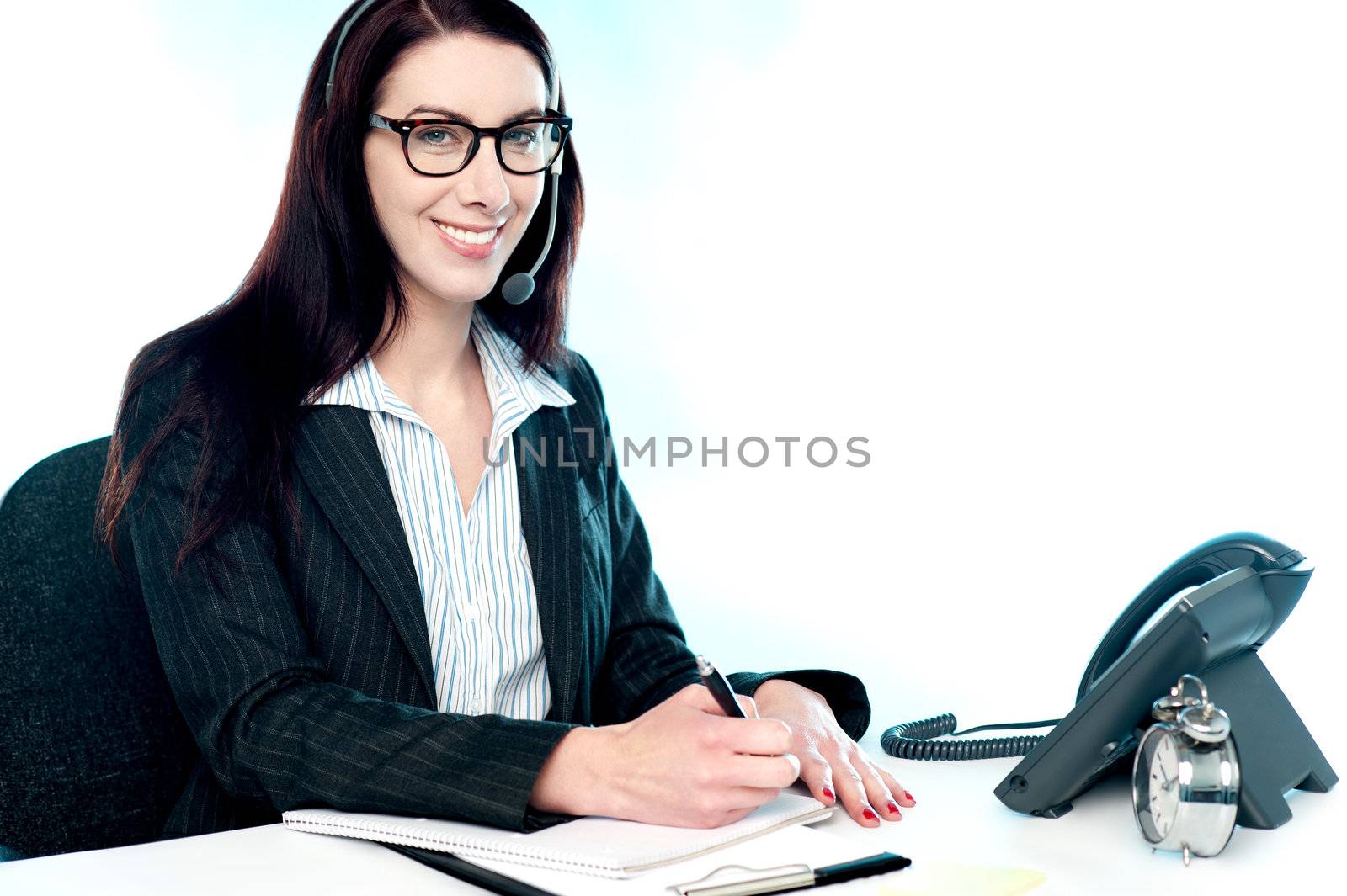 Female customer support executive at her work desk writing clients complain