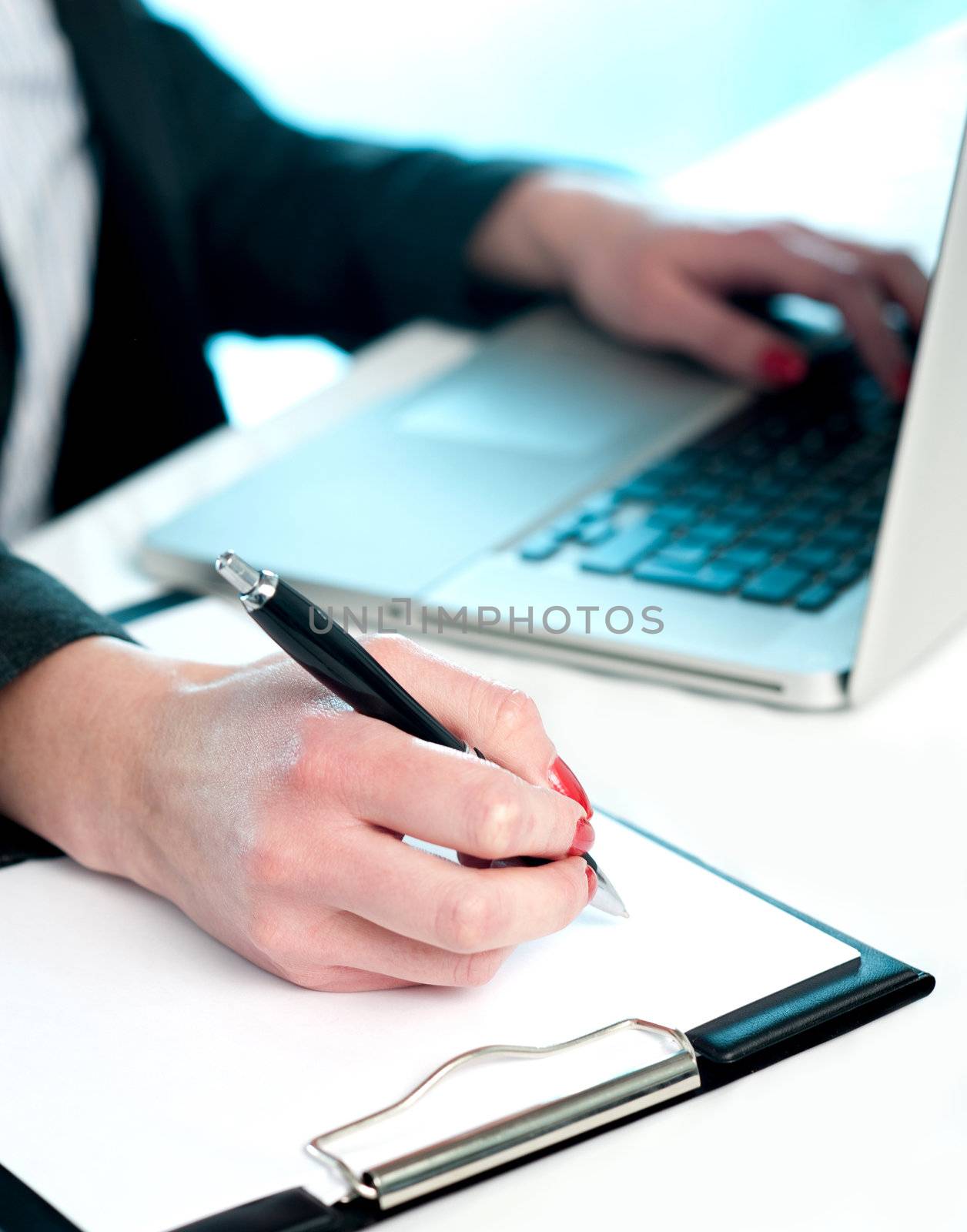 Closeup of woman copying data from laptop to notepad, Making important notes