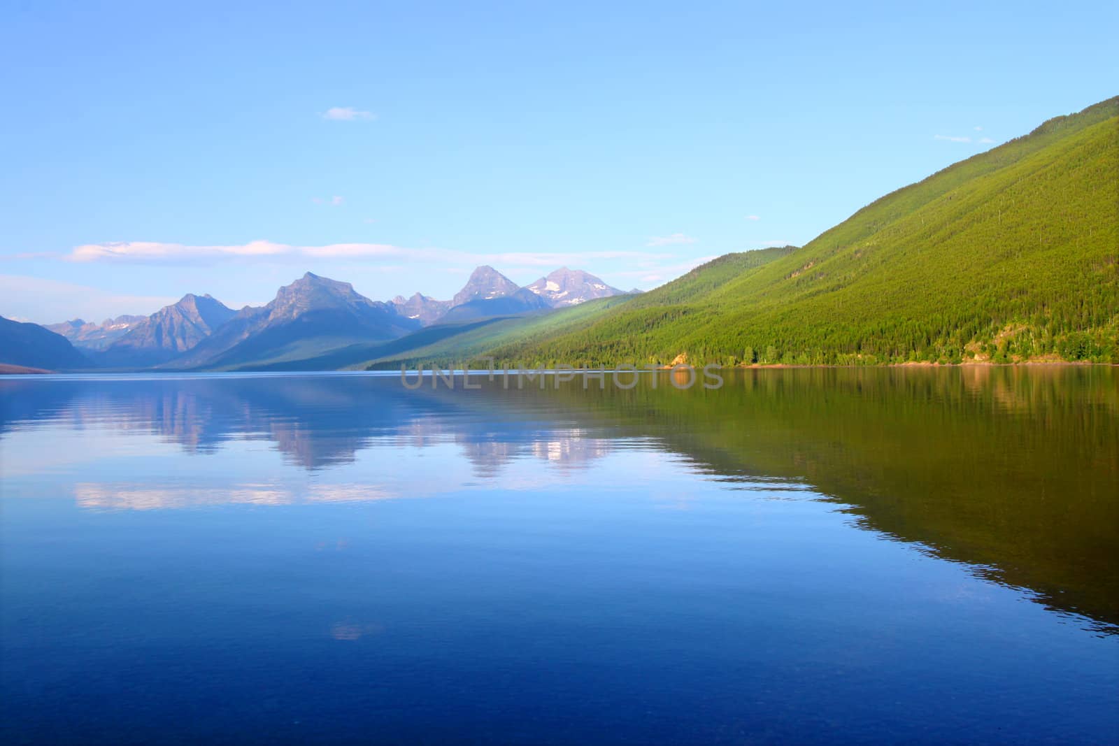 Mountains reflect off Lake McDonald on a calm evening in Glacier National Park.